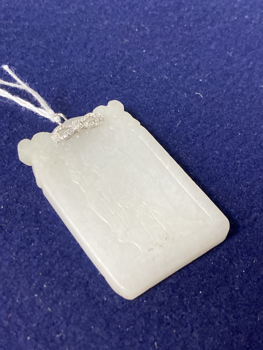 A Chinese diamond set white metal mounted carved white jade pendant, 57mm, gross 35.7 grams.